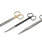 Three professional stainless steel surgical scissors with gold, black, and silver handles on a white background